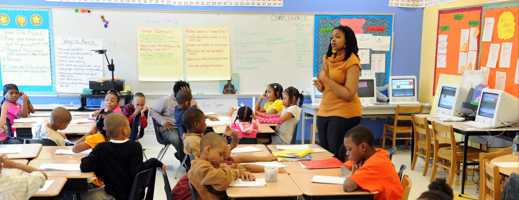 A teacher leads a class of elementary school students