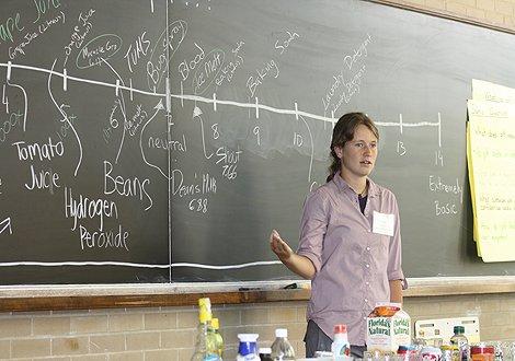 A UTEP student stands in front of a blackboard