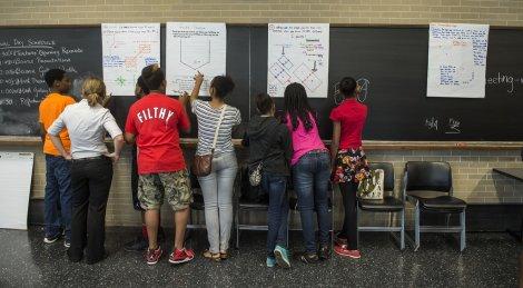 UTEP student gathers around a blackboard with high school students