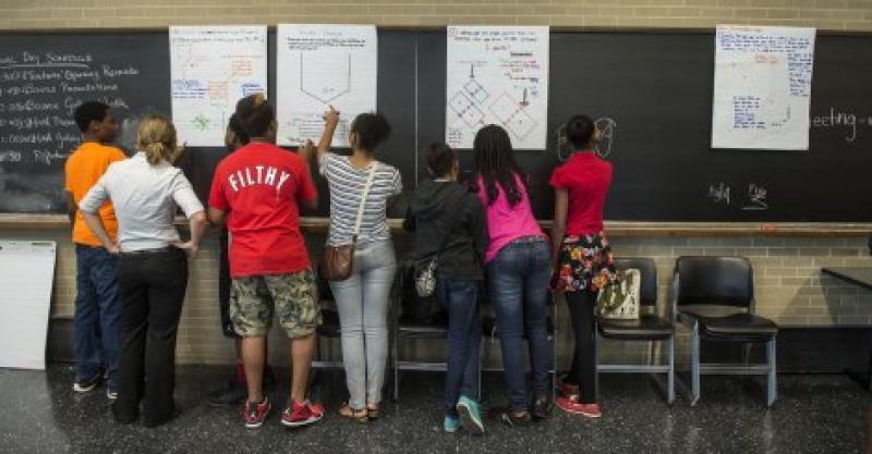 UTEP student gathers around a blackboard with high school students